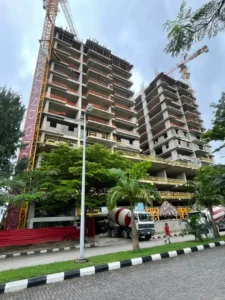 Exterior view of Bijou Tower Banana Island luxury real estate development under construction with paved street and palm trees.