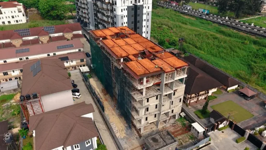 Elizabeth Grace Court III Ikoyi — 4-Bedroom Luxury Maisonette. 3 Aerial view of Elizabeth Grace Court III (EGC 3) Ikoyi under construction with orange roof formwork, scaffolding, surrounding residential buildings, and nearby road in Lagos