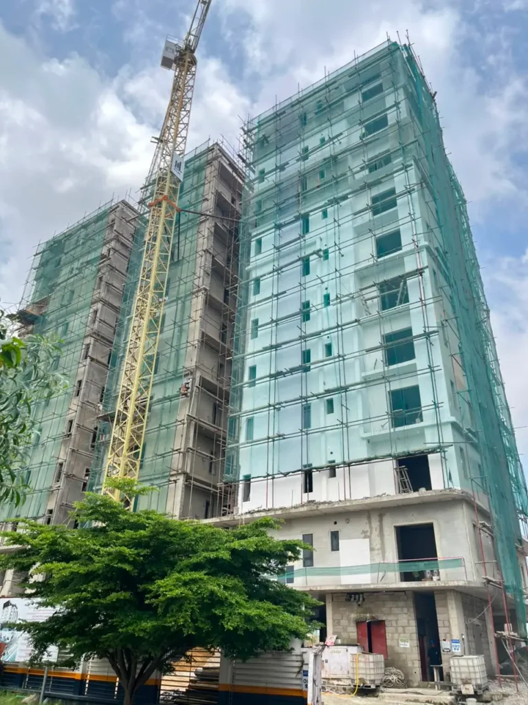 Construction site update photo of Gazania Park Lekki 1 high-rise building with scaffolding green safety nets and tower crane in Lekki