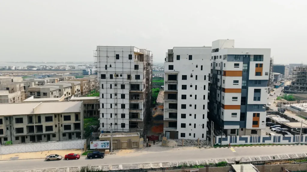 Aerial drone view of The Pantheon Lekki luxury apartment development showing the full complex and surrounding Lekki Lagos neighbourhood with waterfront in the background
